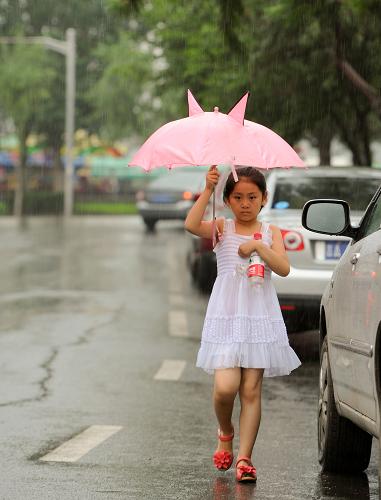 7月28日,長春街頭,一位小朋友撐傘出行。當日,吉林大部地區(qū)出現降雨天氣,吉林省氣象臺于11時20分發(fā)布暴雨藍色預警,提醒相關部門和市民做好防范。新華社發(fā)(張楠 攝)