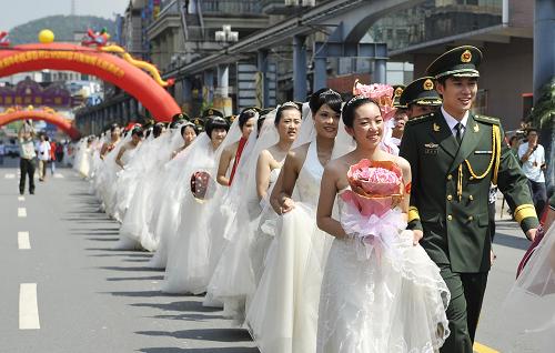 7月30日,新人們攜手走向婚禮現(xiàn)場。 當日,“情系邊關,緣定今生”全國公安邊防百對官兵新人集體婚禮在廣東東莞舉行。 據(jù)了解,參加婚禮的百名官兵來自西藏、新疆等全國29個省、自治區(qū)、直轄市的邊防總隊以及公安邊防院校,大多長年堅守在高原、戈壁、海島等條件艱苦的祖國邊境線上。在現(xiàn)場嘉賓和親友的見證下,百位新人喜結良緣。 新華社記者梁旭攝