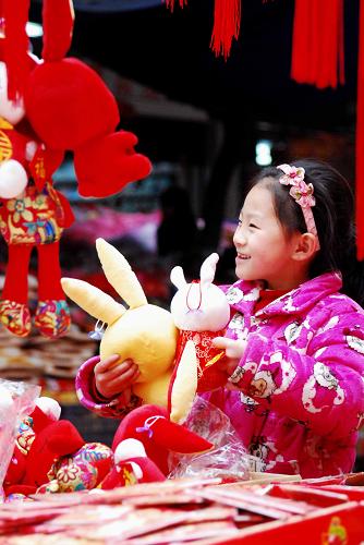 1月15日,在江西省九江市一家年貨店,一名女孩在選購新年飾品。春節(jié)臨近,各地年貨市場紅紅火火,年味越來越濃。新華社發(fā)(胡國林 攝)