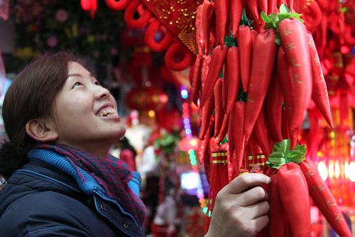 1月15日,一名女青年在湖北省十堰市鄖縣通達(dá)市場內(nèi)選購新年飾品。新華社發(fā)(曹忠宏 攝)