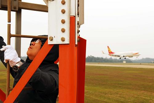 1月15日,民航海南空管分局雷達(dá)導(dǎo)航工程師在檢查??诿捞m機(jī)場(chǎng)航向天線。新華社發(fā)(潘華清 攝)