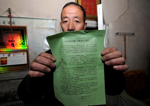在遼寧建平,一位當(dāng)?shù)厝罕娫谡故?009年9月鎮(zhèn)政府發(fā)布的“致張家營(yíng)子鎮(zhèn)廣大群眾的一封信”(1月20日拍攝)。新華社記者 李鋼 攝