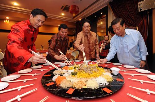 2月2日,在印尼首都雅加達一個華人聚會上,人們準備享用“撈生”。在印度尼西亞華人華僑的年夜飯中,“撈生”必定是頭道菜。“撈生”也叫“撈魚生”,即加上很多配料的生魚片。講究的配料有炸芋頭絲、紅白蘿卜絲、炸粉絲等共十幾道。新年吃魚意味著吉利。魚和菜蔬分別盛在圓碟子里,撒上胡椒和調(diào)味品。食客用筷子攪拌各種配料,做著向上攪調(diào)的姿勢。據(jù)說,此舉象征著在未來的事業(yè)中發(fā)財和幸運。 新華社記者 姜帆 攝