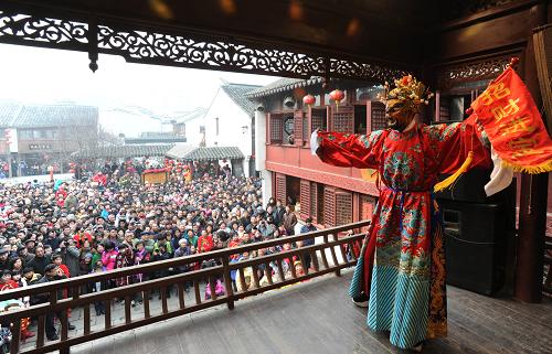 2月7日,裝扮成“財(cái)神”的民俗演員在江蘇蘇州山塘街古戲臺(tái)表演。新華社發(fā)(杭興微 攝)