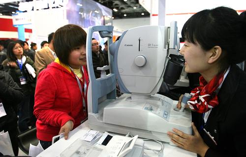 3月25日,觀眾在展會上體驗一款眼部拍照設備。新華社發(fā)(趙冰 攝)