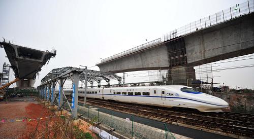 4月2日傍晚,一列動車組列車從武咸城際鐵路跨武廣高鐵特大橋連續(xù)箱梁轉(zhuǎn)體部位通過。 4月3日凌晨,位于湖北省咸寧市橫溝橋鎮(zhèn)的我國首座跨高鐵特大橋——武咸城際鐵路跨武廣高鐵特大橋兩邊各重達(dá)4500噸的連續(xù)箱梁實現(xiàn)成功轉(zhuǎn)體,為武咸城際鐵路的按期通車奠定了基礎(chǔ)。 武咸城際鐵路跨武廣高鐵特大橋全長1483.534米,主跨80米連續(xù)箱梁斜跨武廣高鐵,與營業(yè)線夾角為155°。由于武廣高鐵行車密度大,在施工中,中鐵十一局集團(tuán)一公司通過搭設(shè)安全防護(hù)棚架,加強(qiáng)安全教育和值班巡檢等舉措,確保了該橋的施工安全及武廣高鐵的運(yùn)營安全。 新華社記者 杜華舉 攝