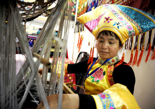 4月20日,在義烏“文博會”非物質(zhì)文化遺產(chǎn)展區(qū),廣西壯族婦女演示古老的織錦技藝。新華社發(fā)(張建成 攝)