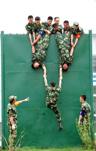 4月21日,公安邊防部隊烏魯木齊指揮學(xué)校學(xué)員團結(jié)協(xié)作完成心理行為訓(xùn)練中的“翻越畢業(yè)墻”項目。新華社發(fā)(林鑫 攝)