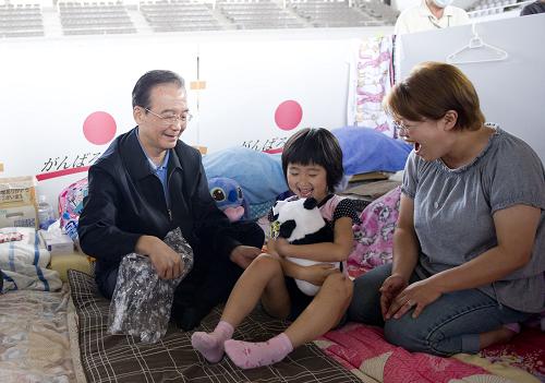 5月21日,國務(wù)院總理溫家寶訪問了日本宮城縣名取市和福島縣福島市災(zāi)區(qū),代表中國政府和人民向災(zāi)區(qū)民眾表示誠摯慰問。這是溫家寶在日本福島吾妻綜合運動公園體育館避難所慰問災(zāi)民時,向避難所里的小女孩贈送大熊貓毛絨玩具。新華社記者 黃敬文 攝