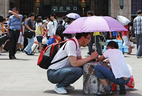 6月3日,在北京火車站進站口前,一對父子在等待進站。新華社發(fā)(李方宇 攝)