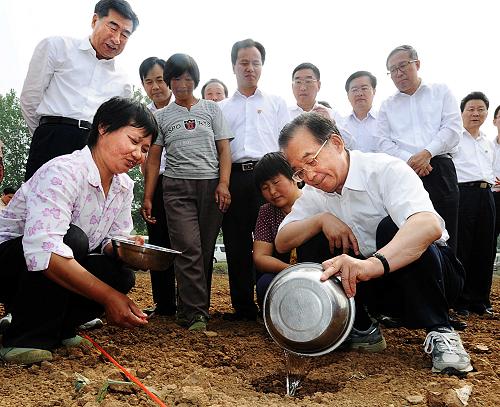 這是6月4日,在湖北省襄陽市老河口市洪山嘴鎮(zhèn)楊灣村的玉米地里,溫家寶與村民一起播種澆水。新華社記者 李濤 攝