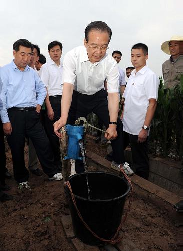 這是6月2日,在湖南省岳陽市君山區(qū)柳林洲鎮(zhèn)新洲村一處棉田里,溫家寶從機井中壓水為村民龔義成家的棉苗澆水。新華社記者 李濤 攝