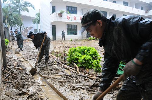 6月7日,連夜從安順趕來的武警官兵在幫助受災(zāi)學(xué)校清淤。新華社記者 石新榮 攝