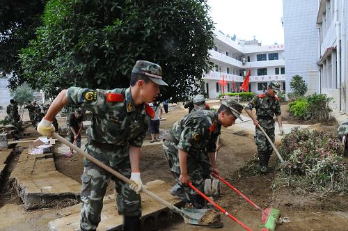 6月9日,專程從安順趕來的武警官兵在幫助受災學校清淤。貴州望謨洪澇災害發(fā)生后,造成縣城基礎(chǔ)設(shè)施損毀、學校、街道等多處淤泥堆積,易引發(fā)疾病和次生災害,武警官兵和當?shù)厝罕妸^戰(zhàn)在清理淤泥的第一線上。新華社記者 石新榮 攝