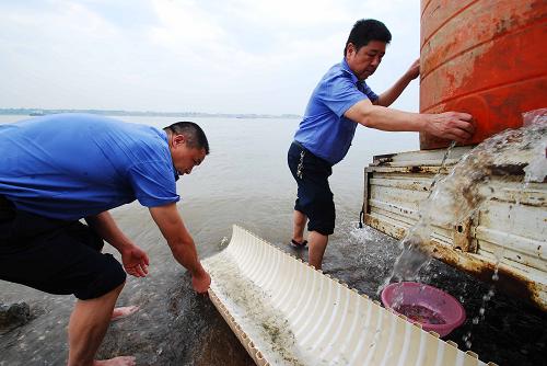 6月9日,江西九江市漁政部門工作人員在長(zhǎng)江九江段水域放流魚苗。新華社發(fā)(胡國林 攝)
