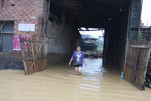 6月10日,湖南省婁底市新化縣西河鎮(zhèn)沙江村村民走在被雨水淹沒的道路上。新華社發(fā)(郭國(guó)權(quán) 攝)