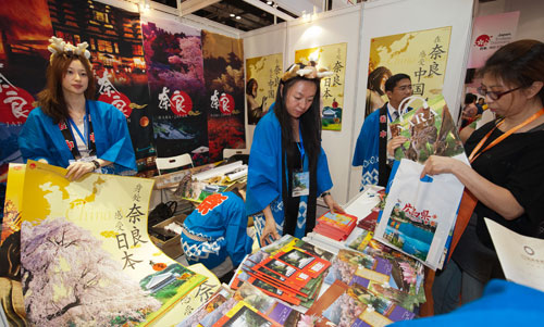 6月17日,在2011北京國際旅游博覽會(huì)上,日本奈良縣參展團(tuán)向觀眾發(fā)放宣傳品。為盡快振興震后旅游業(yè),日本組成本屆博覽會(huì)的最大國際參展團(tuán),展區(qū)的面積超過200平方米。新華社記者 張宇 攝