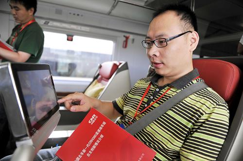 6月21日,一位記者在體驗(yàn)高鐵列車上的多媒體信息終端。新華社記者 朱崢 攝