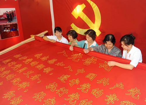 6月26日,幾名參觀展覽的黨員在工作人員幫助下繡“入黨誓詞”。新華社記者 羅曉光 攝