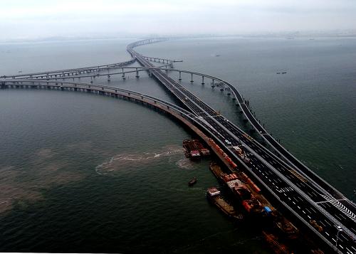 這是航拍的青島膠州灣大橋(6月21日攝)。 2011年6月30日,青島膠州灣大橋正式通車,這是我國北方冰凍海域首座特大型橋梁集群工程,是國道主干線青島至蘭州高速公路的起點(diǎn)段,大橋全長36.48公里,是目前世界上已建成的最長的跨海大橋。大橋起于青島市東部高科園,跨越膠州灣,在黃島側(cè)與已建成的濟(jì)青南線順接,使青島、黃島和紅島實(shí)現(xiàn)“品”字形連接。大橋?yàn)殡p向六車道高速公路兼城市快速路八車道,設(shè)計(jì)行車速度80公里每小時(shí),橋梁寬度35米,設(shè)計(jì)基準(zhǔn)期100年。 新華社發(fā)(鄢潤波 攝)