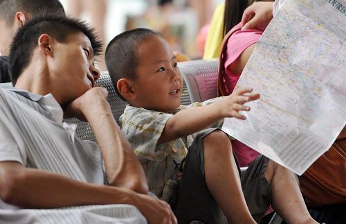 7月1日,在合肥火車站候車室,一名小旅客在翻看地圖。新華社記者 劉軍喜 攝