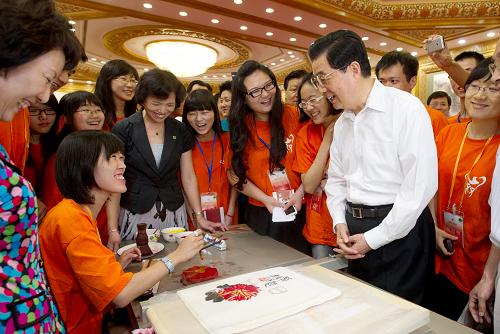 7月12日,中共中央總書記胡錦濤在北京人民大會堂參加兩岸萬名青年大交流主題聯(lián)歡活動。這是胡錦濤同正在嘗試用木版水印技藝復(fù)制國畫作品的臺灣青年親切交談。新華社記者 李學(xué)仁 攝