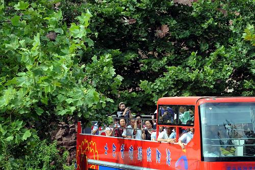 在通往黃河小浪底景區(qū)的公路上,游客們乘坐旅游觀光巴士賞景、拍照(6月22日攝)。新華社記者王頌攝