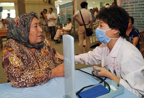 7月21日,北京市援疆醫(yī)療專家李小宇在為一位維吾爾族婦女檢查身體。當日,來自北京市積水潭醫(yī)院、安貞醫(yī)院的14名專家在新疆和田地區(qū)人民醫(yī)院開展義診,受到和田各族群眾的歡迎。據(jù)了解,幾年來,北京市醫(yī)療部門共向和田選派援疆醫(yī)生53名。和田地區(qū)還派出當?shù)氐尼t(yī)療骨干到北京各大醫(yī)院接受培訓,目前有34名醫(yī)療人員在京接受培訓。新華社記者 趙戈 攝