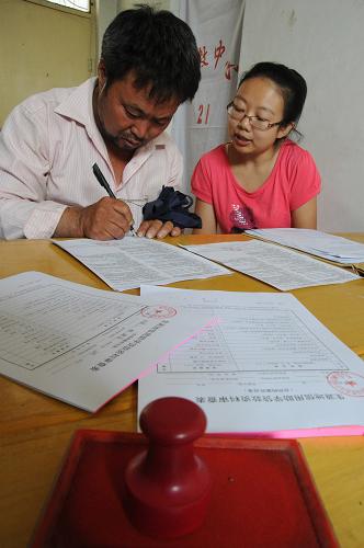 8月9日,在山西運城市一生源地信用助學貸款管理中心,一名大學生家長(左)在填寫貸款審查表。新華社發(fā)(高新生 攝)