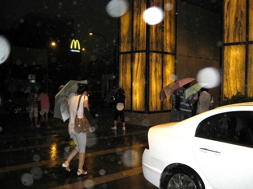 8月9日17時許,行人在暴雨中穿越街道。當日,立秋后的北京城首次遭遇強對流雷電暴雨襲擊,部分街道出現(xiàn)積水,交通受阻。新華社記者 汪永基 攝