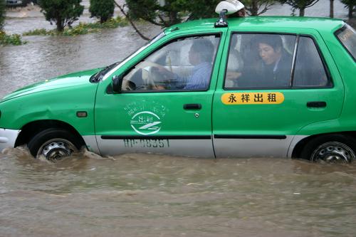 8月15日,一輛出租車在甘肅省甘南州合作市區(qū)內(nèi)的積水中行駛。新華社發(fā)(吉合塔 攝)