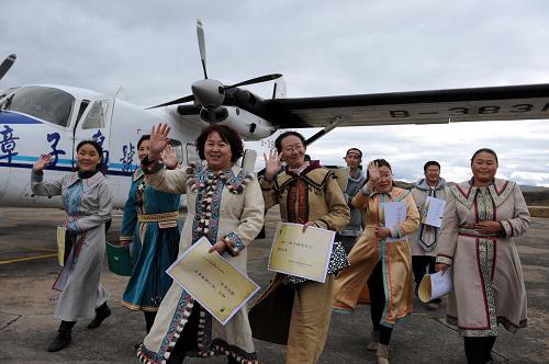 9月15日,來自根河市敖魯古雅鄂溫克民族鄉(xiāng)的鄂溫克族獵民德柯麗(前左一)與同伴們興高彩烈地走下飛機(jī)。新華社記者 張領(lǐng) 攝