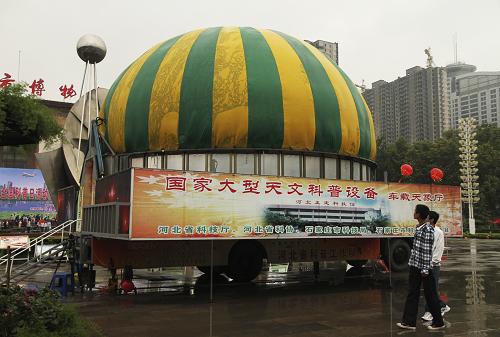 9月17日,參觀者從停放在邯鄲市博物館廣場(chǎng)前的大型車載天象廳前經(jīng)過。當(dāng)日,一款車載天象廳在邯鄲市博物館廣場(chǎng)亮相并向市民開放。據(jù)介紹,車載天象廳以斗長(zhǎng)8米的卡車作為底盤,可自動(dòng)伸縮為直徑8米的半圓球天象廳,通過天象儀模擬星空演示,自動(dòng)播放各種天象節(jié)目,方便公眾能隨時(shí)隨地觀看天象,探尋宇宙的奧秘,每場(chǎng)可容納80名觀眾。新華社發(fā)(王九忠 攝)