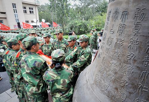 9月17日,身著軍訓(xùn)服的南開大學(xué)2011級新生在紀(jì)念“九一八”事變80周年儀式上鳴鐘。新華社發(fā)(游思行 攝)