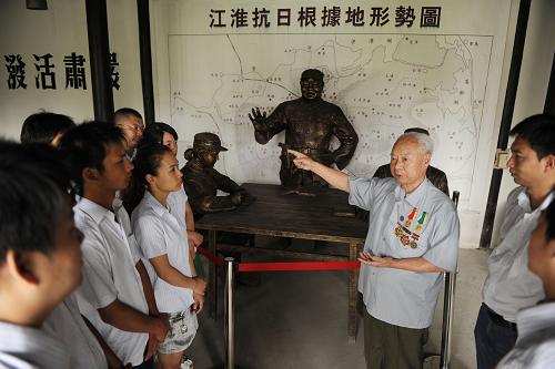 9月16日,新四軍老戰(zhàn)士高維田(右三)在為參觀者講述自己在江淮抗日根據(jù)地的戰(zhàn)斗經(jīng)歷。新華社發(fā)(宋衛(wèi)星 攝)