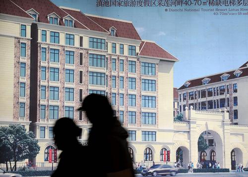 9月24日,兩位市民從一幅樓盤的廣告宣傳畫前走過。新華社記者 藺以光 攝