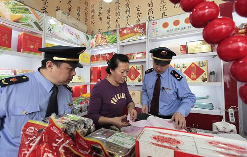 9月27日,北京東城工商分局工作人員在一家商店內(nèi)核查北京特產(chǎn)果脯的進(jìn)貨渠道。新華社發(fā)(羅偉 攝)