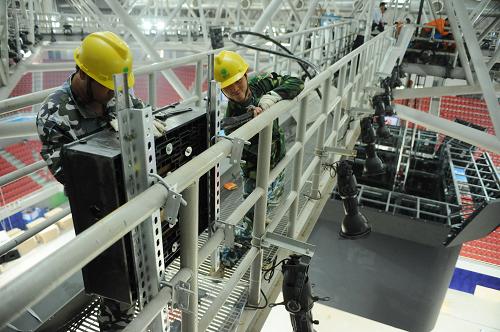 10月5日,電力公司工人在離地40米高的運(yùn)動(dòng)場(chǎng)館鋪設(shè)電路,這里將舉行“七城會(huì)”閉幕式活動(dòng)。距離“七城會(huì)”在江西南昌開幕只有十天時(shí)間,為保證開閉幕式電力供應(yīng),江西電力部門正在加緊對(duì)相關(guān)場(chǎng)館進(jìn)行供電設(shè)備的鋪設(shè)、安裝等工作。新華社記者 周密 攝