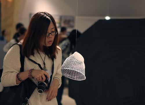 一位觀眾在欣賞展品“空氣花瓶”(10月3日攝)。首屆北京國際設(shè)計(jì)三年展于2011年9月28日- 10月17日在北京中國國家博物館舉行。展覽空間總面積約6000平方米,圍繞“仁:設(shè)計(jì)的善意”為總主題,由“知‘竹’”、“理智設(shè)計(jì)情感”、“創(chuàng)意聯(lián)結(jié)”、“混合現(xiàn)實(shí)”、“可能的世界”五類分主題構(gòu)成。恰逢十一黃金周舉辦的此次展覽,不僅為廣大設(shè)計(jì)師和藝術(shù)愛好者提供了近距離觀看國際前沿設(shè)計(jì)作品的機(jī)會(huì),也讓十一期間來京觀光的游客大飽了眼福。新華社發(fā)(馮思默 攝)