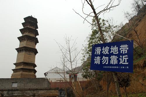 陜西長(zhǎng)安華嚴(yán)寺內(nèi)的妙覺塔旁掛起了“滑坡地帶 請(qǐng)勿靠近”的警示牌(11月21日攝)。 位于陜西西安市長(zhǎng)安區(qū)少陵原畔的佛教華嚴(yán)宗祖庭——華嚴(yán)寺內(nèi)僅存的兩座古塔面臨著山體滑坡造成的巨大威脅。 華嚴(yán)寺內(nèi)現(xiàn)存的兩座古塔于2006年被納入第六批全國重點(diǎn)文物保護(hù)單位。在2011年5月、6月和9月的數(shù)次集中降雨中,華嚴(yán)寺周邊多處發(fā)生山體滑坡,其中建于唐代的杜順?biāo)乃言诨轮胁糠致懵?,距離古塔一米左右的地面上裂開了長(zhǎng)達(dá)數(shù)米的裂縫,妙覺塔旁的齋房的地基也遭到極大破壞,寺院內(nèi)的其他房屋也在滑坡中遭到不同程度的損壞。 由于近期西安仍不時(shí)出現(xiàn)降雨天氣,已經(jīng)遭到較大破壞的華嚴(yán)寺古塔目前面臨著極大的滑坡威脅。 新華社記者 李一博 攝