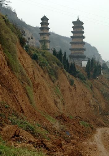 陜西長(zhǎng)安華嚴(yán)寺周邊的山體發(fā)生多處滑坡(11月21日攝)。 位于陜西西安市長(zhǎng)安區(qū)少陵原畔的佛教華嚴(yán)宗祖庭——華嚴(yán)寺內(nèi)僅存的兩座古塔面臨著山體滑坡造成的巨大威脅。 華嚴(yán)寺內(nèi)現(xiàn)存的兩座古塔于2006年被納入第六批全國重點(diǎn)文物保護(hù)單位。在2011年5月、6月和9月的數(shù)次集中降雨中,華嚴(yán)寺周邊多處發(fā)生山體滑坡,其中建于唐代的杜順?biāo)乃言诨轮胁糠致懵?,距離古塔一米左右的地面上裂開了長(zhǎng)達(dá)數(shù)米的裂縫,妙覺塔旁的齋房的地基也遭到極大破壞,寺院內(nèi)的其他房屋也在滑坡中遭到不同程度的損壞。 由于近期西安仍不時(shí)出現(xiàn)降雨天氣,已經(jīng)遭到較大破壞的華嚴(yán)寺古塔目前面臨著極大的滑坡威脅。 新華社記者 李一博 攝