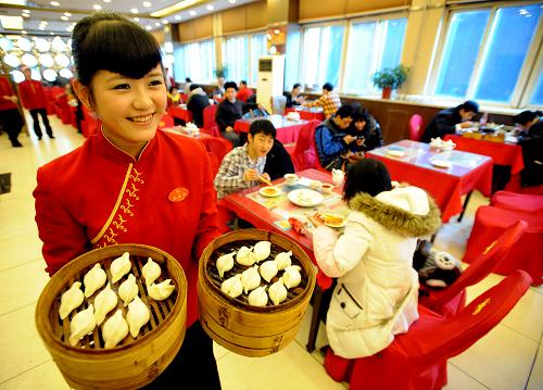 12月22日,在沈陽老邊餃子館,工作人員給顧客上餃子。12月22日是我國農歷二十四節(jié)氣中的冬至,我國北方地區(qū)有吃餃子的習俗。當日沈陽各大飯店的餃子生意十分紅火。新華社發(fā)(張文魁 攝)