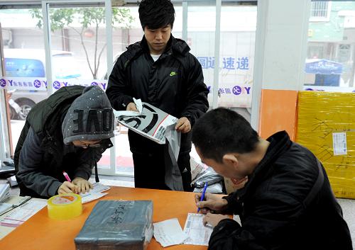 12月29日,網(wǎng)店的員工向義烏一家駐地快遞公司寄交網(wǎng)購(gòu)包裹。新華社發(fā)(張建成 攝)