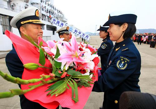 12月29日,海軍女戰(zhàn)士在歡迎儀式上向任務(wù)指揮員、東海艦隊副司令員邱延鵬少將(左一)等獻花。新華社記者 查春明 攝