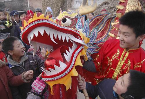 這是1月13日,在山東聊城朱老莊鎮(zhèn)趙樓村,孩子們在近距離接觸舞龍。新華社發(fā)(張振祥 攝)