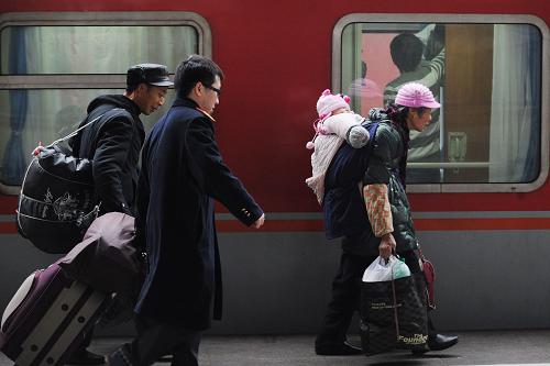 1月28日,兩名帶小孩前往西安的老年旅客在車站工作人員的協(xié)助下進(jìn)站乘車。重慶火車北站預(yù)計(jì)當(dāng)日發(fā)送旅客7萬(wàn)多人次。新華社記者 李健 攝