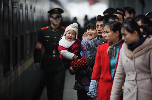1月28日,一位前往杭州的母親懷抱小孩在重慶火車北站站臺(tái)等候乘車。重慶火車北站預(yù)計(jì)當(dāng)日發(fā)送旅客7萬(wàn)多人次。新華社記者 李健 攝