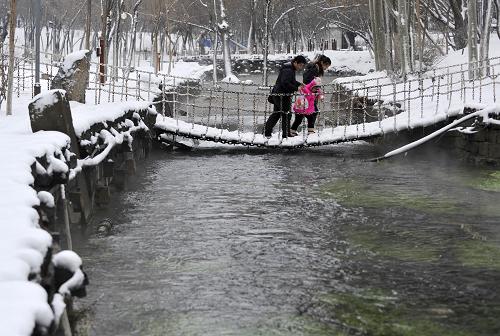 3月20日,幾位市民在烏魯木齊市水磨溝公園中欣賞雪景。新華社記者 王菲 攝