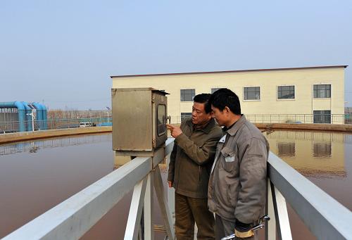 兩名工作人員在污水處理廠二次沉淀池查看污水處理情況(3月20日攝)。新華社發(fā)(張超群 攝)