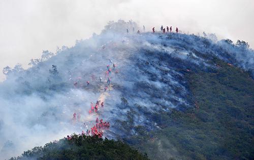 3月22日,一些森林警察在云南安寧王家灘森林火災(zāi)現(xiàn)場進(jìn)行撲救。當(dāng)日凌晨,云南安寧王家灘森林火災(zāi)火場出現(xiàn)復(fù)燃,距離附近的九渡村只有約400米左右。目前有數(shù)百名森林武警、消防官兵和解放軍戰(zhàn)士正在全力撲救,已經(jīng)開辟了一條五公里長的防火隔離帶,現(xiàn)場還有部分明火,但控制在隔離帶外,火災(zāi)對村莊尚無直接影響。新華社記者 藺以光 攝
